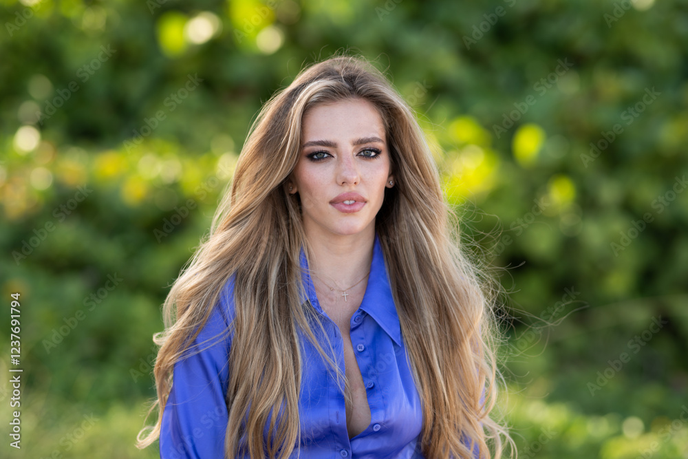 Naklejka premium Beauty woman face. Beautiful tender young woman look sensual outdoor. Charming elegance beauty sexy lady on spring or summer background. Tenderness portrait of young woman with make up.