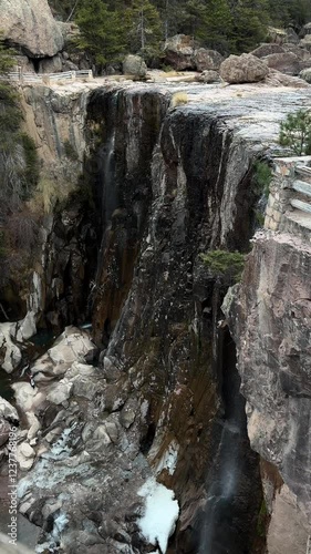 Vertical shot of Cusarare waterfall while it's raining in day in Chihuahua, Mexico photo