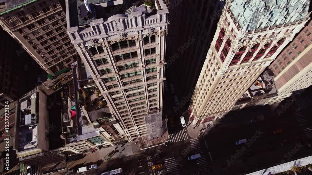 A dynamic drone clip starting with a top-down view of historic skyscrapers and seamlessly transitioning to a panoramic shot of New York City's skyline under clear blue skies.