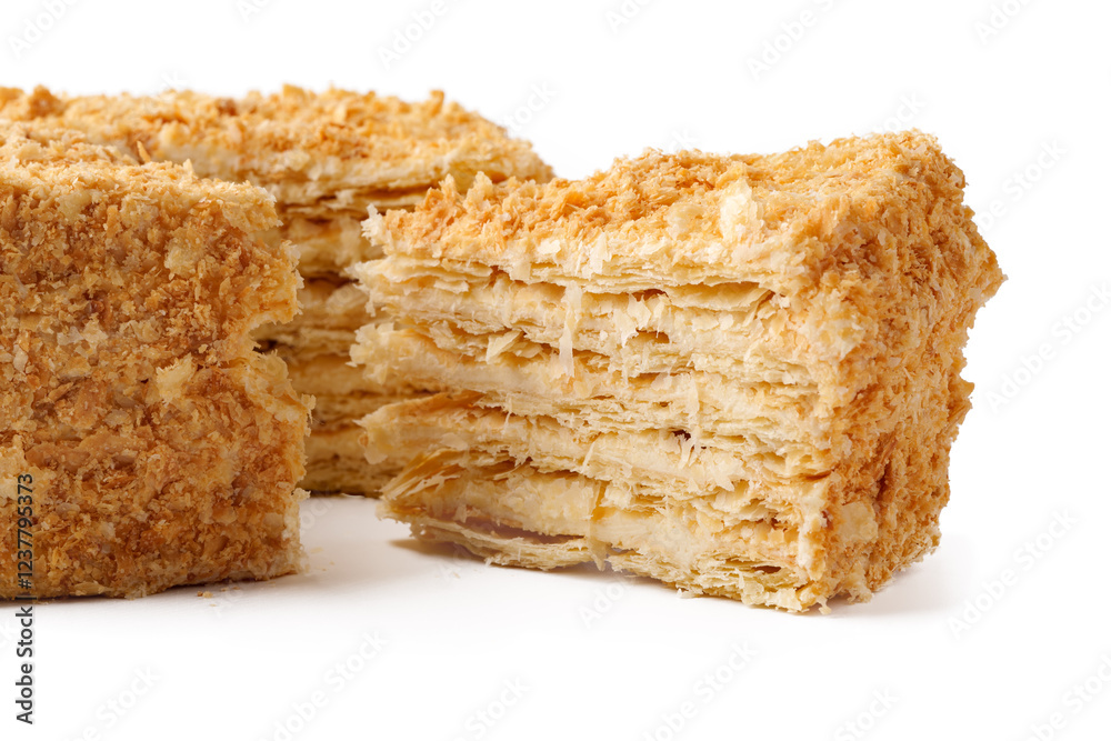 Delicious layered pastry with cream filling and crunchy topping on a white background showcasing its texture Delicious layered pastry with cream filling and crunchy topping on a white background showcasing its texture