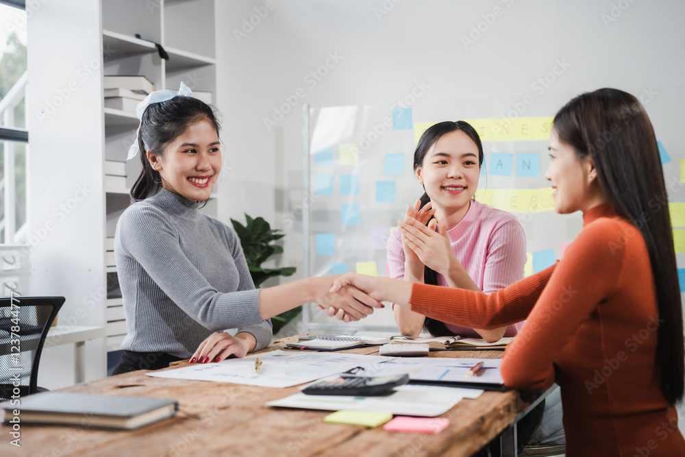 Shaking hands, Asian people, motivated businesswoman at her desk, brainstorming creative ideas to kickstart her startup venture with determination and innovation. purpose and ambition. only women. Shaking hands, Asian people, motivated businesswoman at her desk, brainstorming creative ideas to kickstart her startup venture with determination and innovation. purpose and ambition. only women.