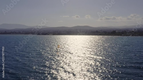 Wind surfer under the sun beam on a sunny day