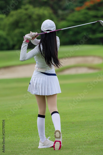 Wallpaper Mural  Asian woman happy and fun while playing golf on the golf course. Golfer hitting golf shot with driver club on course. Beautiful woman smiling and holding a golf club while standing on green lawn. Torontodigital.ca