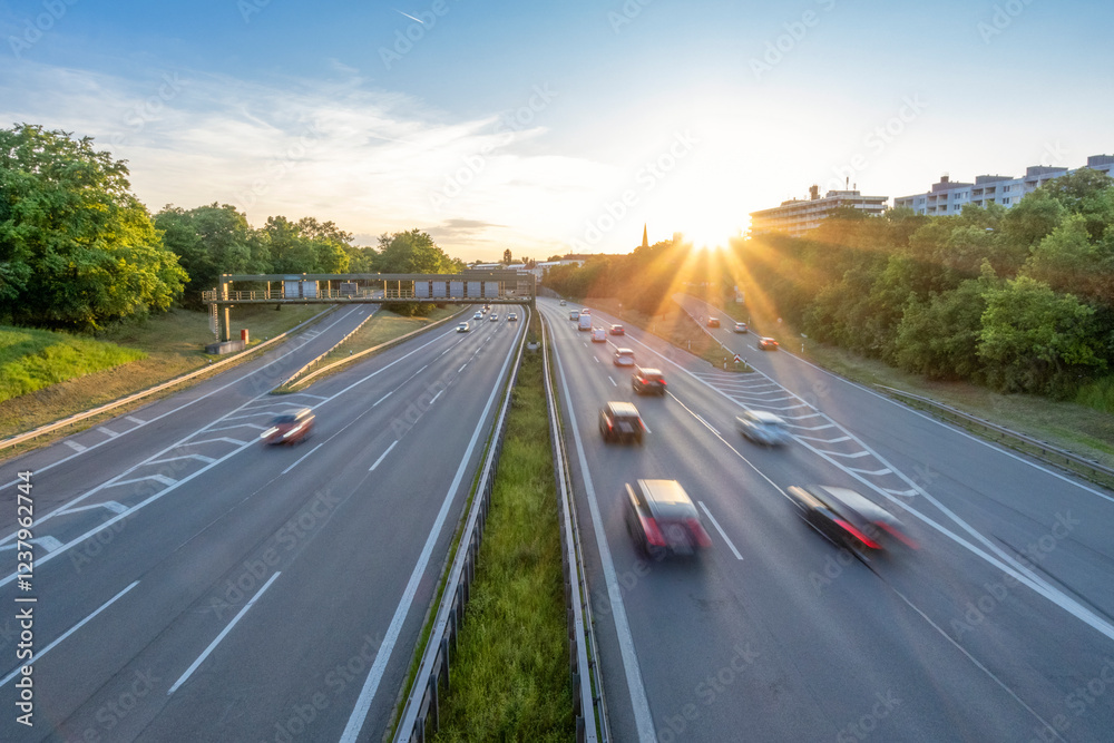 Cars moving in speed on highway at sunset