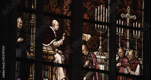bishop and priests depicted in stained glass window in cathedral Linz