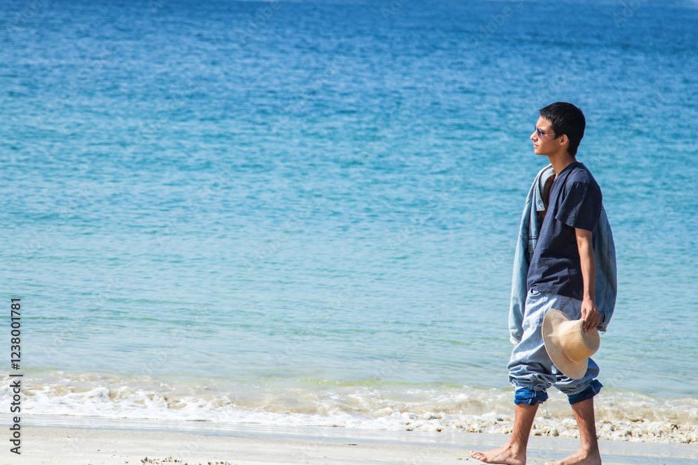 young man with hat enjoying himself on the beach shore young man with hat enjoying himself on the beach shore