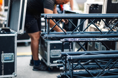 Stage hand unloading truss for outdoor event photo