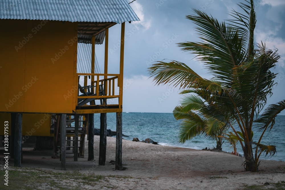 Fototapeta premium Yellow Beach Hut and Palm Tree by the Ocean