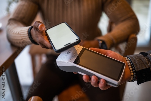 Close up of  man makes a contactless payment with smartphone in the bar.