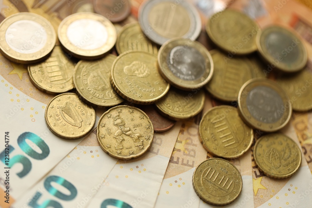 Many cent coins of euro currency lies on many fifty euro bills banknotes Many cent coins of euro currency lies on many fifty euro bills banknotes