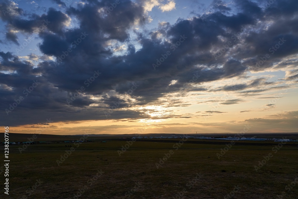 Sunset over expansive grassland with dramatic clouds. Sunset over expansive grassland with dramatic clouds.