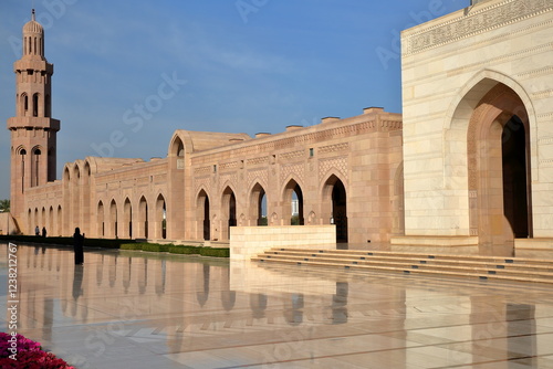 The Sultan Qaboos Grand Mosque in Muscat, Oman, with reflections of a row of arcades and a minaret
