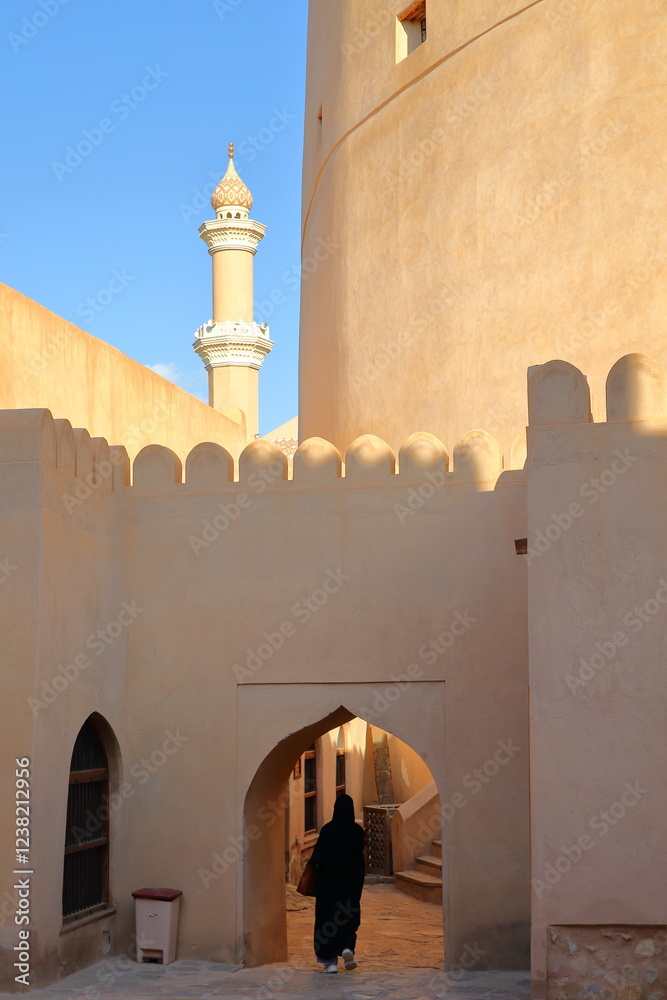 The Nizwa fort in Nizwa, Al Dakhiliyah, Oman, with the minaret of the Mosque in the background