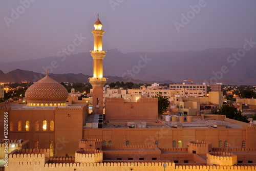 Obraz na płótnie General night view of the town of Nizwa, Al Dakhiliyah, Oman, with the mosque, its minaret and the ramparts of Nizwa fort in the foreground. Picture taken during the blue hour w salonie