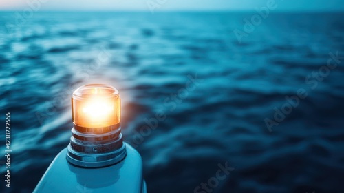 As the sun sets and the sky begins to darken, the navigational lights of a yacht shine brilliantly, casting a warm glow over the serene, calm waters of the ocean