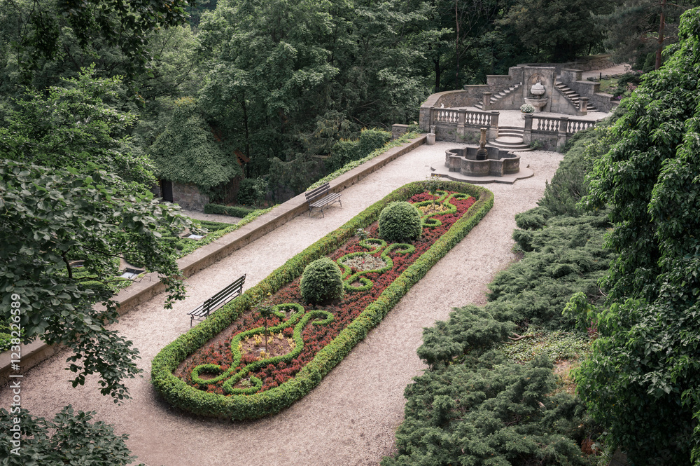 Formal Garden with a Fountain, Bench and Lush Greenery.