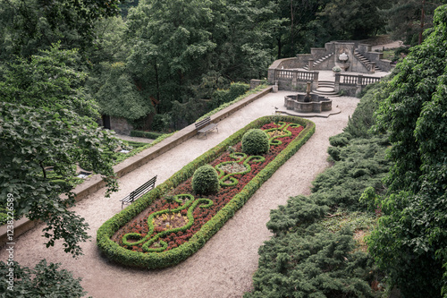 Obraz na płótnie Formal Garden with a Fountain, Bench and Lush Greenery. w salonie