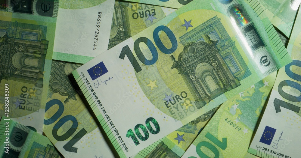 One hundred euro bills are randomly placed on the table. View from above. The camera moves in a circle One hundred euro bills are randomly placed on the table. View from above. The camera moves in a circle