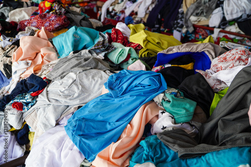 A large pile of used clothing in various colors and styles. A messy collection of secondhand garments. A Huge Pile of Colorful Used Clothing