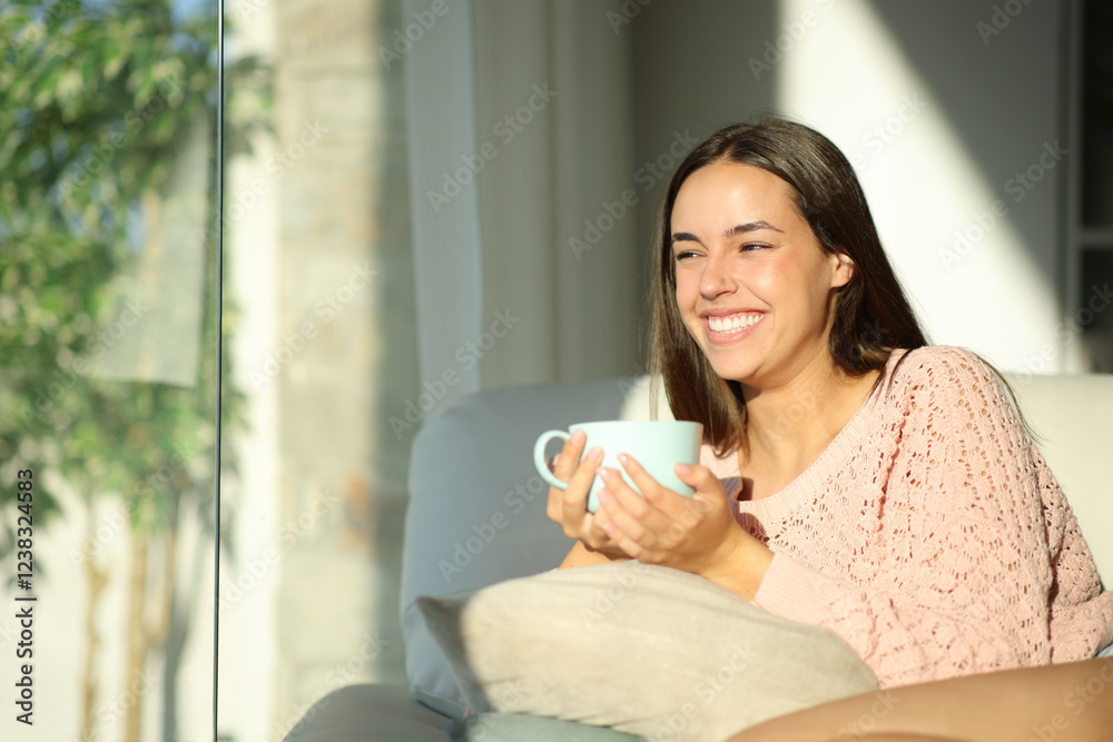 Happy woman drinking and contemplating at home Happy woman drinking and contemplating at home
