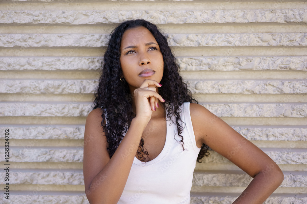 A Contemplative Young Woman Engaged in Deep Thought Set Against a Textured Background A Contemplative Young Woman Engaged in Deep Thought Set Against a Textured Background