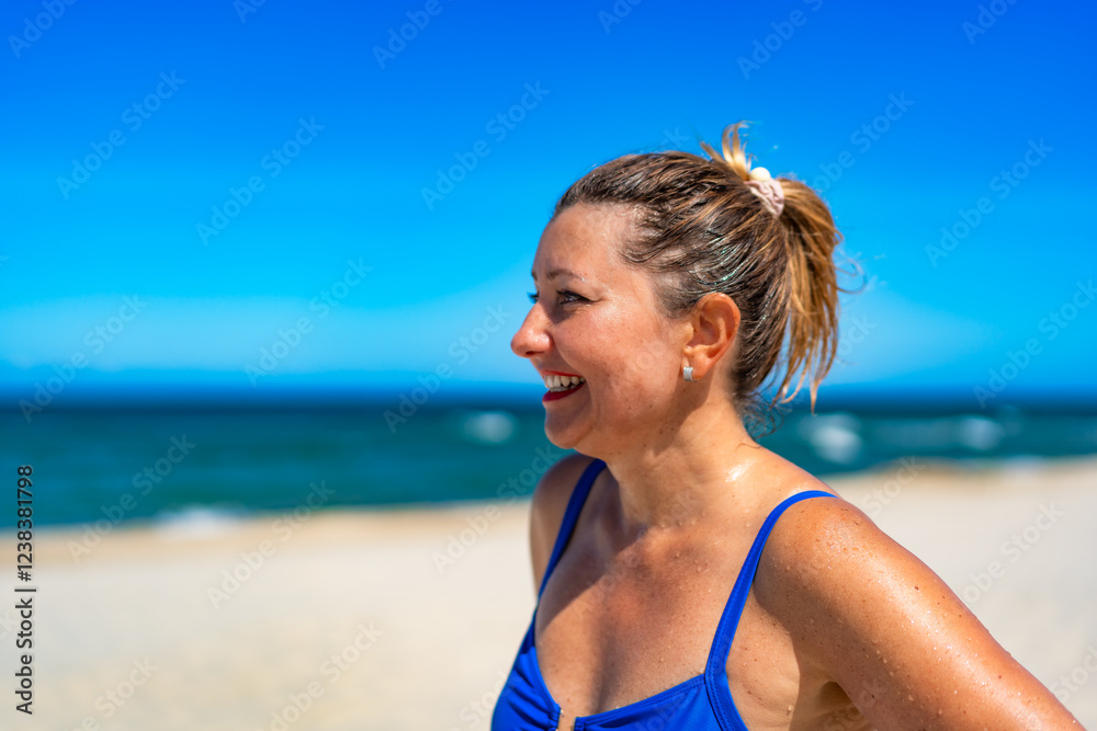 Naklejka premium Portrait of beautiful happy middle aged woman against beach background. Pretty smiling female face in summertime