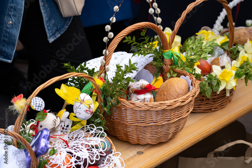 Easter basket for blessing in a church. Traditional woven wicker Paschal basket or Kosz wielkanocny filled with various food, ready to be blessed by a priest as part of the Easter tradition. photo