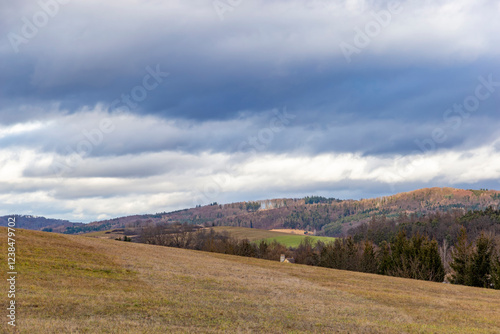 Obraz na płótnie A landscape with forested hills in early spring.