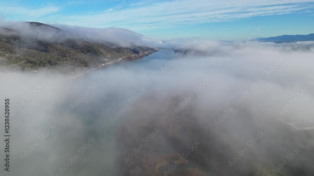 Drone Flight Over the Rhone River in Southern France, with Dense Morning Fog Rising Above the River, Illuminated by Sunlight in Le Pouzin Drone Flight Over the Rhone River in Southern France, with Dense Morning Fog Rising Above the River, Illuminated by Sunlight in Le Pouzin