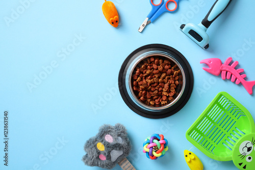 Cat care essentials on a blue background, including food bowl with kibble, grooming tools, toys, and litter scoop. Perfect for pet care, veterinary themes photo