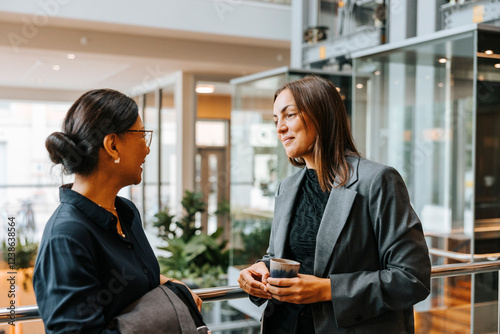 Smiling female business professionals discussing during networking event at convention center photo