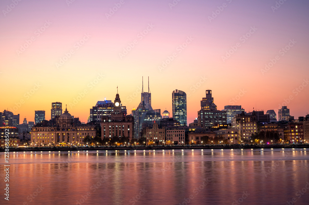 Sunset of Shanghai city modern skyscraper night light cityscape in twilight golden sky of Historical architecture on the bund of Shanghai with reflection of buildings in city Shanghai, China