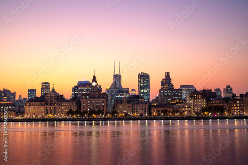 Obraz na płótnie Sunset of Shanghai city modern skyscraper night light cityscape in twilight golden sky of Historical architecture on the bund of Shanghai with reflection of buildings in city Shanghai, China w salonie
