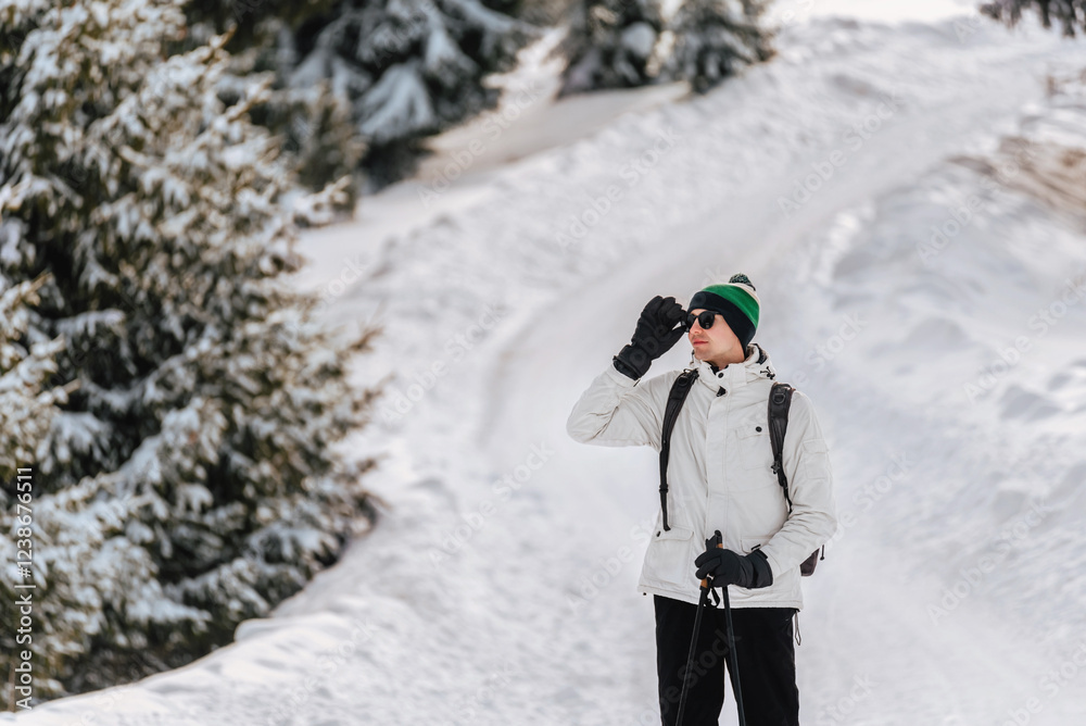 Man Hiking in Snowy Forest with Trekking Poles