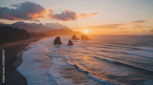 Stunning sunset over rocky coastline with waves and mountains in background