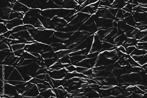 Burnt or charred creased paper abstract texture. Black and white grunge background with noise or grain