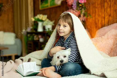 Wallpaper Mural Little toddler child, boy, lying in bed with pet dog, little maltese dog, reading a book, nice light Torontodigital.ca