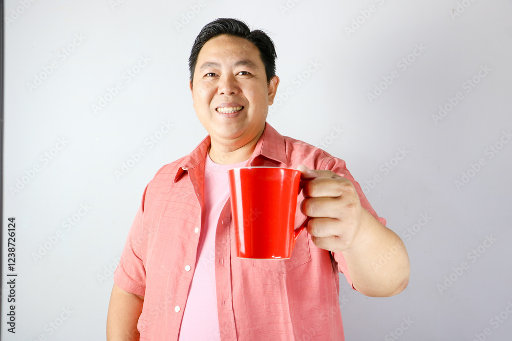 A man holding a red cup for coffee or tea A man holding a red cup for coffee or tea