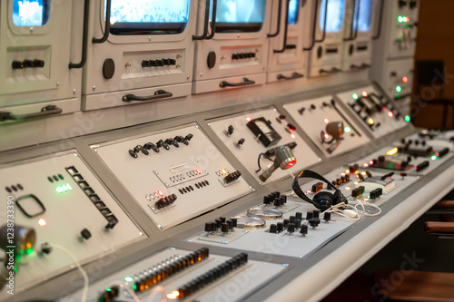 Vintage control panel with monitors, switches, and buttons. Retro technology, surveillance, command center, broadcasting, communications. Ideal for sci-fi, retro-futuristic, or industrial designs
