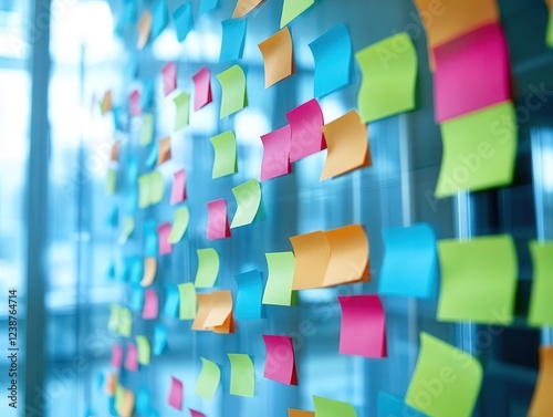 modern office team engaged in dynamic brainstorming session, using colorful sticky notes on glass wall, natural light streaming through windows