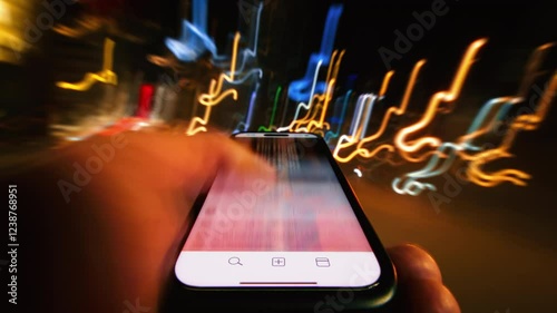 Close-up time-lapse hyperlapse of male hand scrolling social networks on smartphone screen walking city street at night, fast motion light trails, pov cellphone scrolling apps surf internet web pages