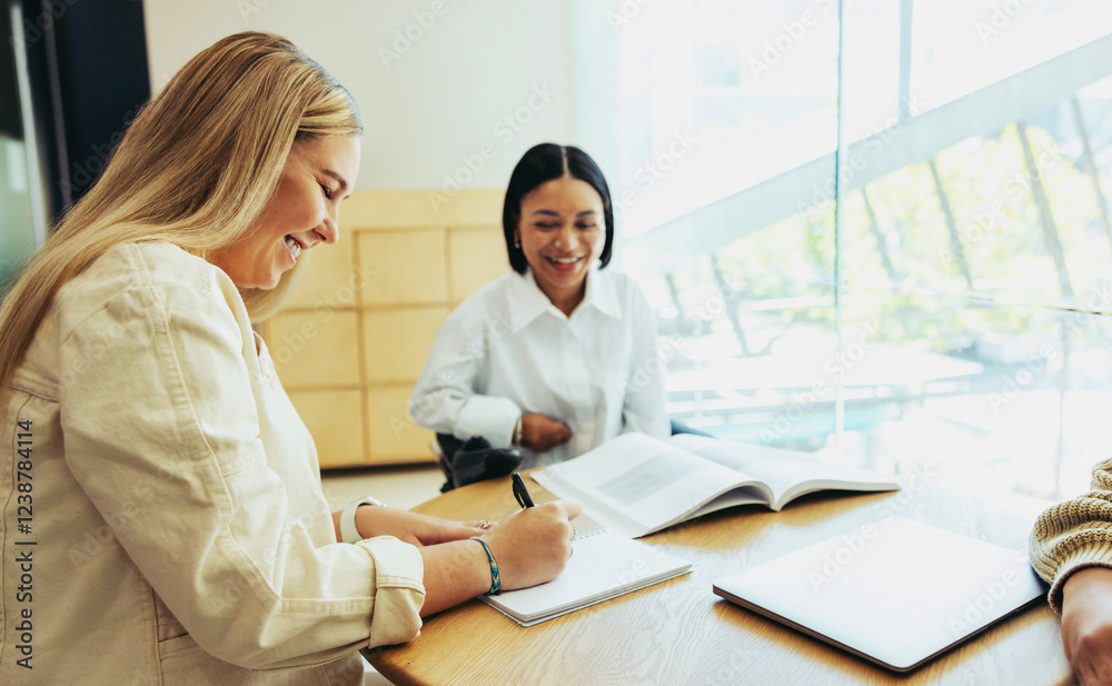 Fototapeta premium Diverse group of students smiling and studying together in a bright city school environment