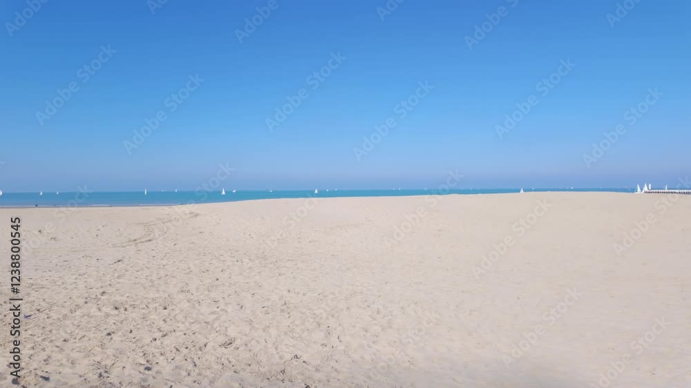 A peaceful and tranquil beach scene showcasing beautiful golden sand, a clear bright sky, and calm gentle waters A peaceful and tranquil beach scene showcasing beautiful golden sand, a clear bright sky, and calm gentle waters