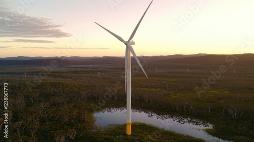 Aerial View of a Wind Turbine Surrounded by Lush Green Fields Under a Vibrant Sunset Sky photo