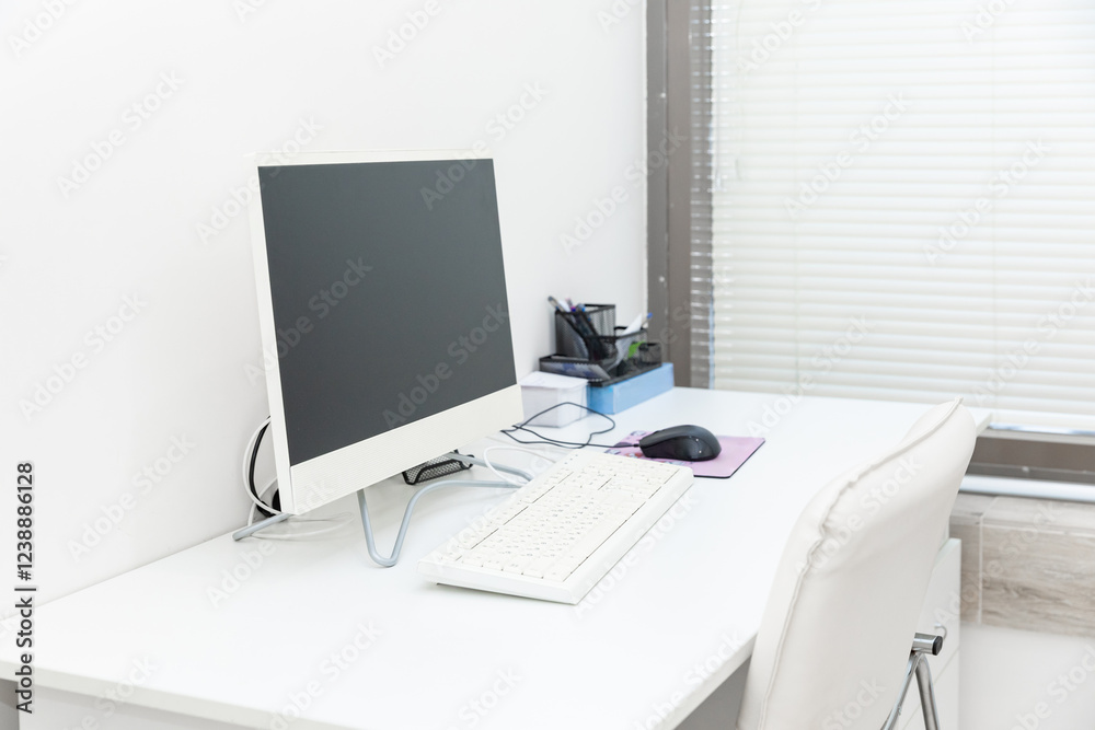 Obraz premium Doctor's workplace with computer. Interior of modern medical office. Empty doctor's office with white furniture and walls. Copy space