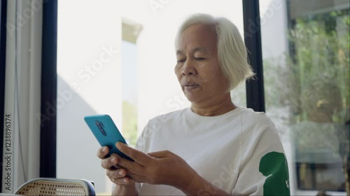 Phone scam call target talk old asian female cyber crime fraud alert on older people. Mature adult retired woman asia parent avoid look at text threats mobile buy pay online banking app social media.