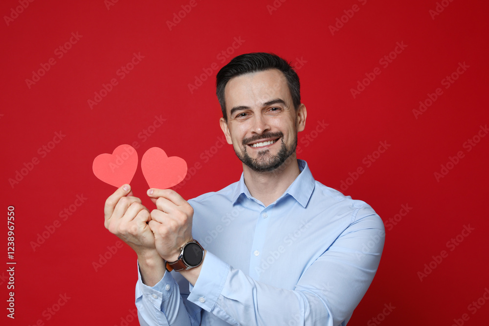Happy Valentine's Day. Handsome man with paper hearts on red background Happy Valentine's Day. Handsome man with paper hearts on red background
