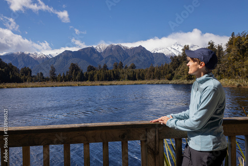 Tourist admiring breathtaking lake matheson view with mount cook and mount tasman in new zealand photo