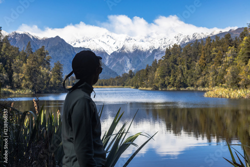 Tourist admiring lake matheson and mount cook in new zealand