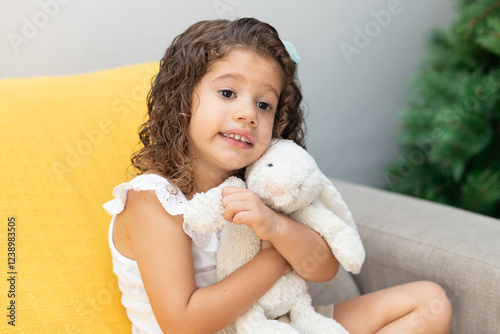 menina abraçada com urso de pelúcia sorrindo photo